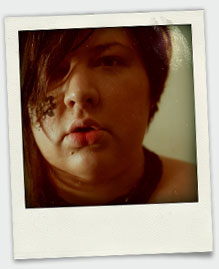 A close up polaroid style photo of me looking to the viewer's left with drawing on my right cheek. 